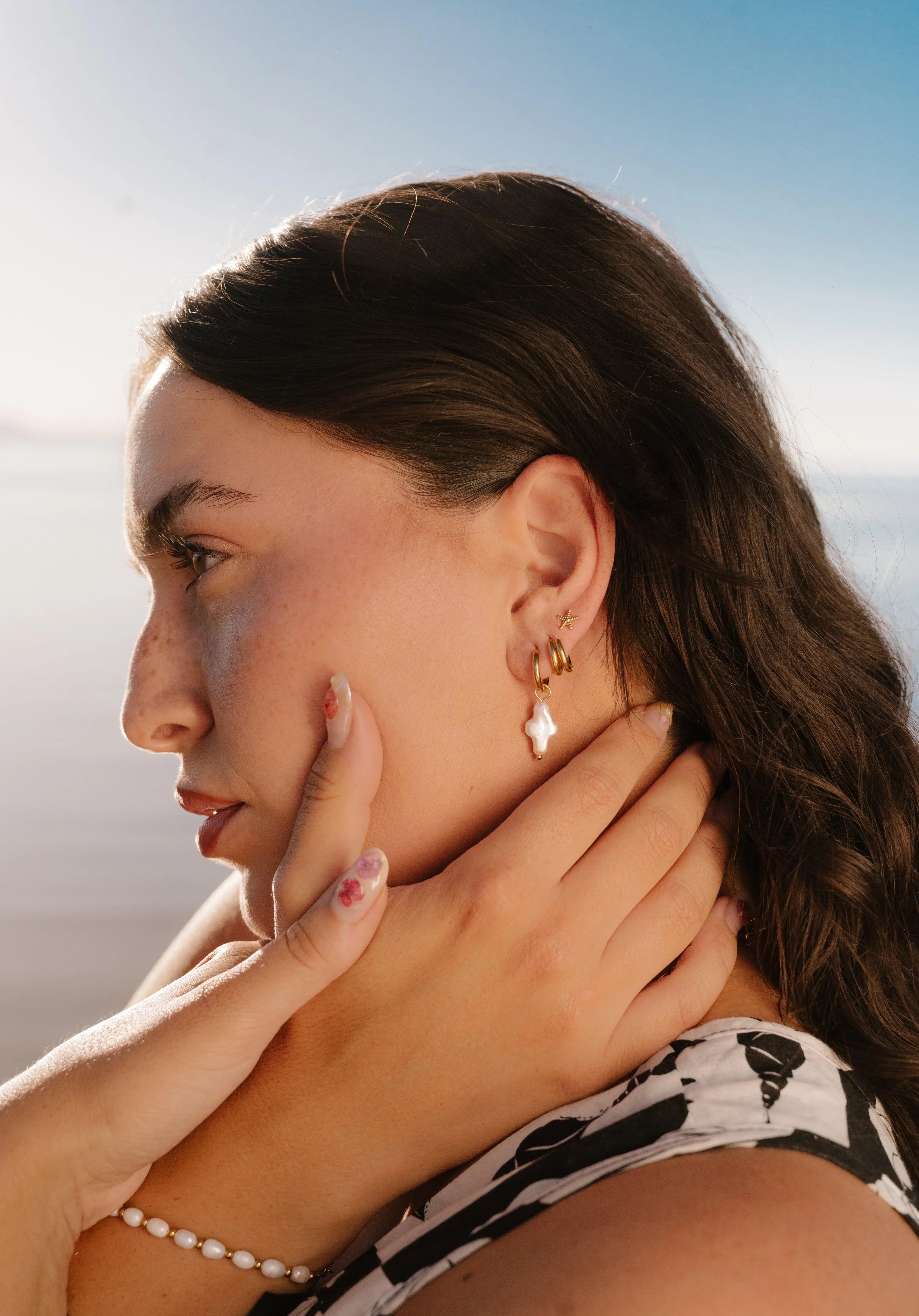 Woman wearing gold earrings with a blurred background