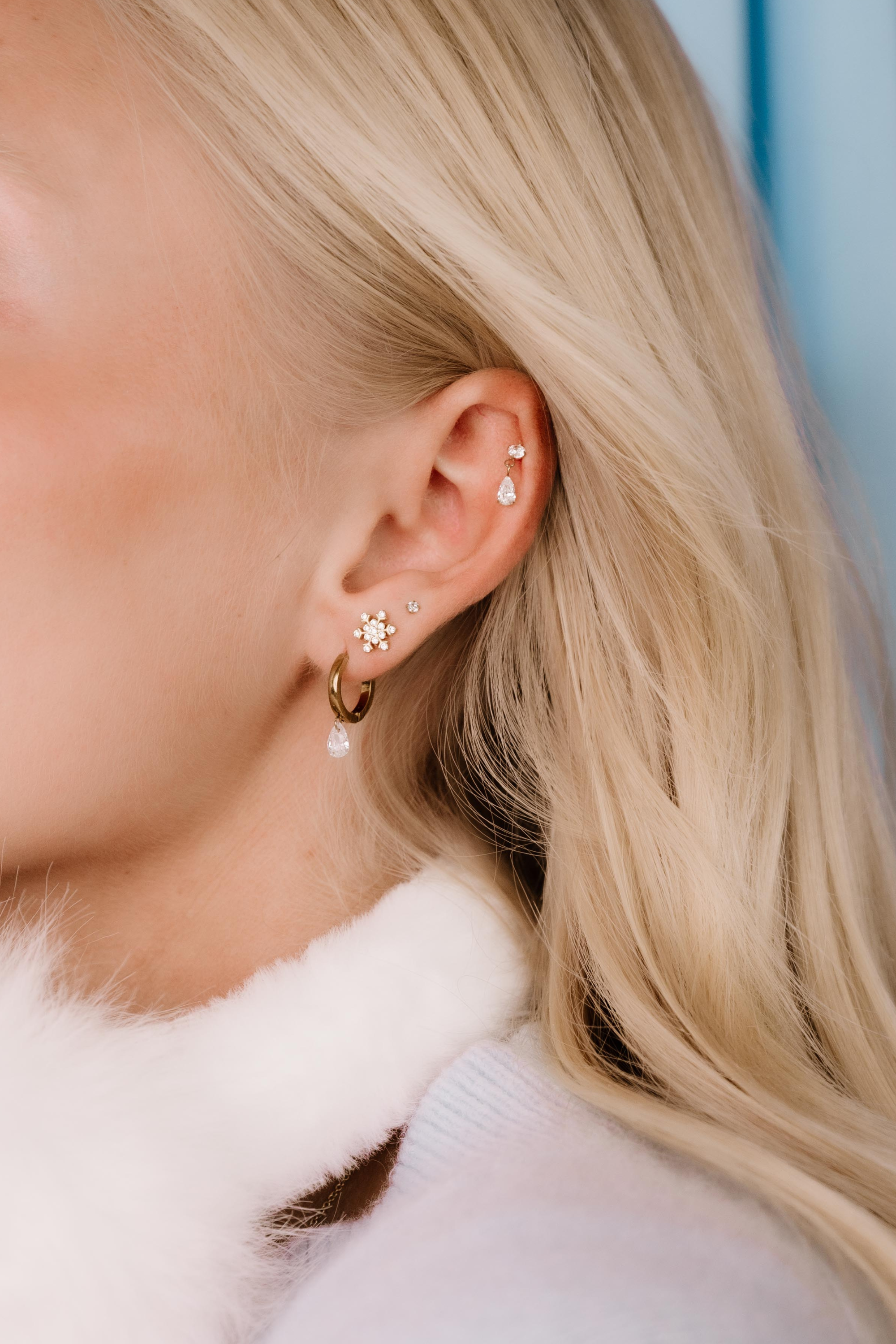 Close-up of a person wearing earrings with a blurred background
