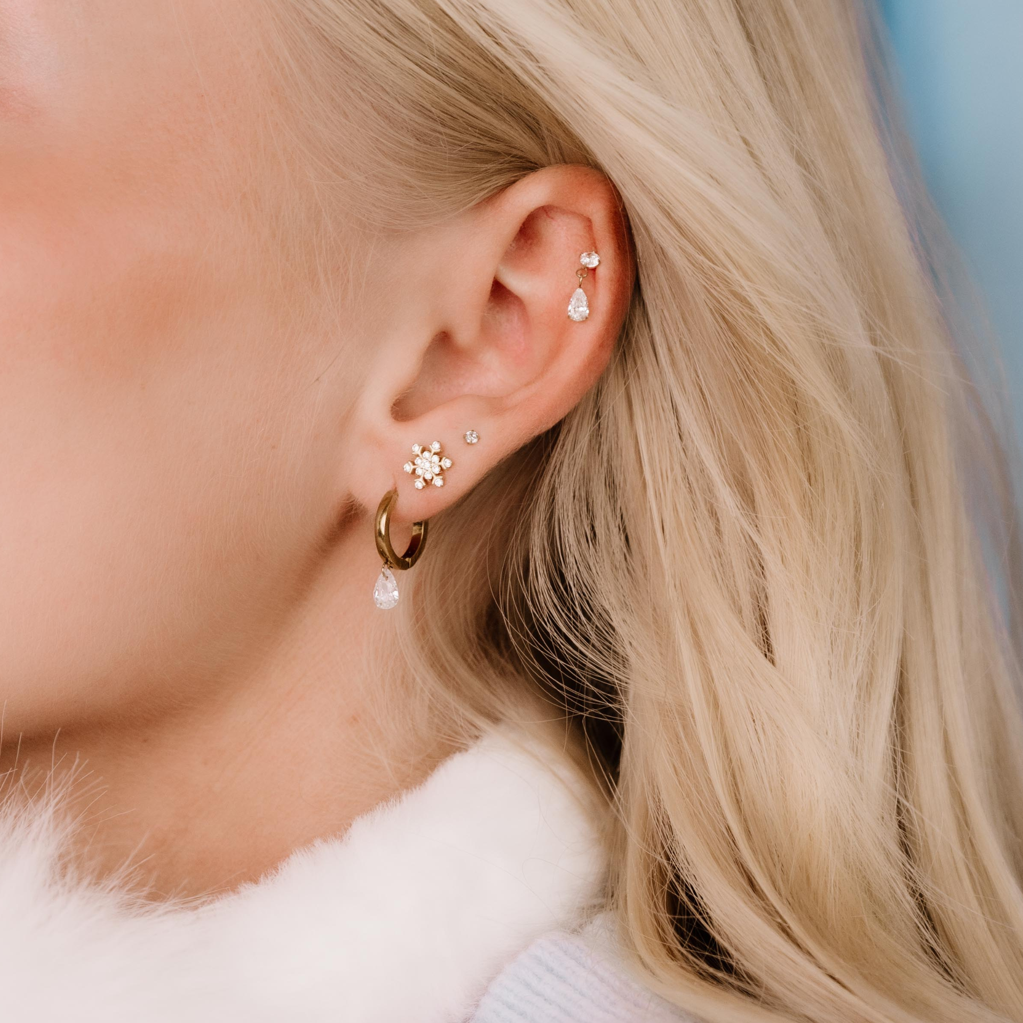 Close-up of a person wearing earrings with a blurred background