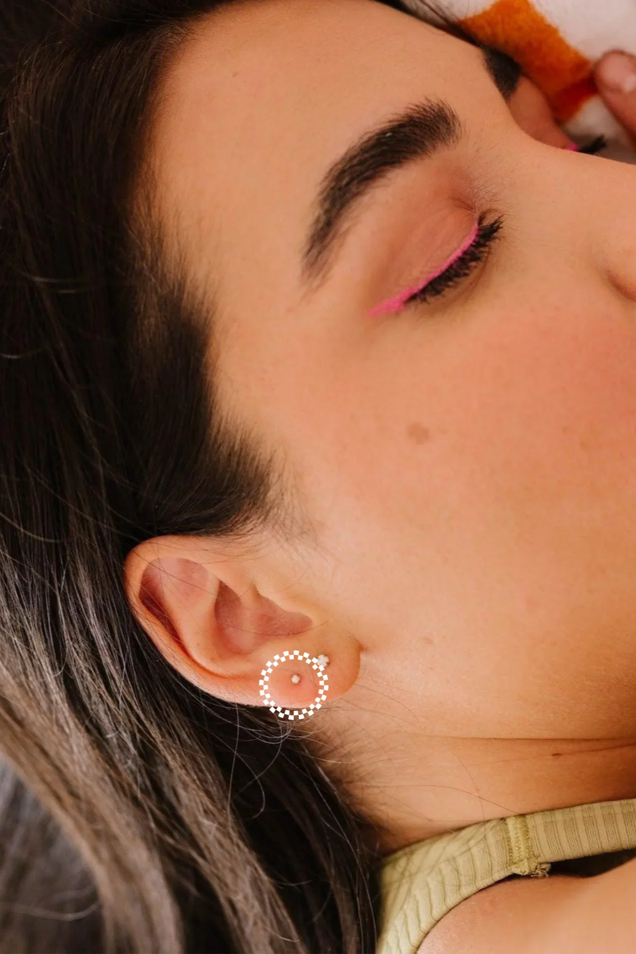 Close-up of a woman wearing a circular earring with a blurred background