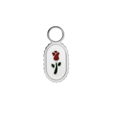 Small oval charm with a red rose design on a white background