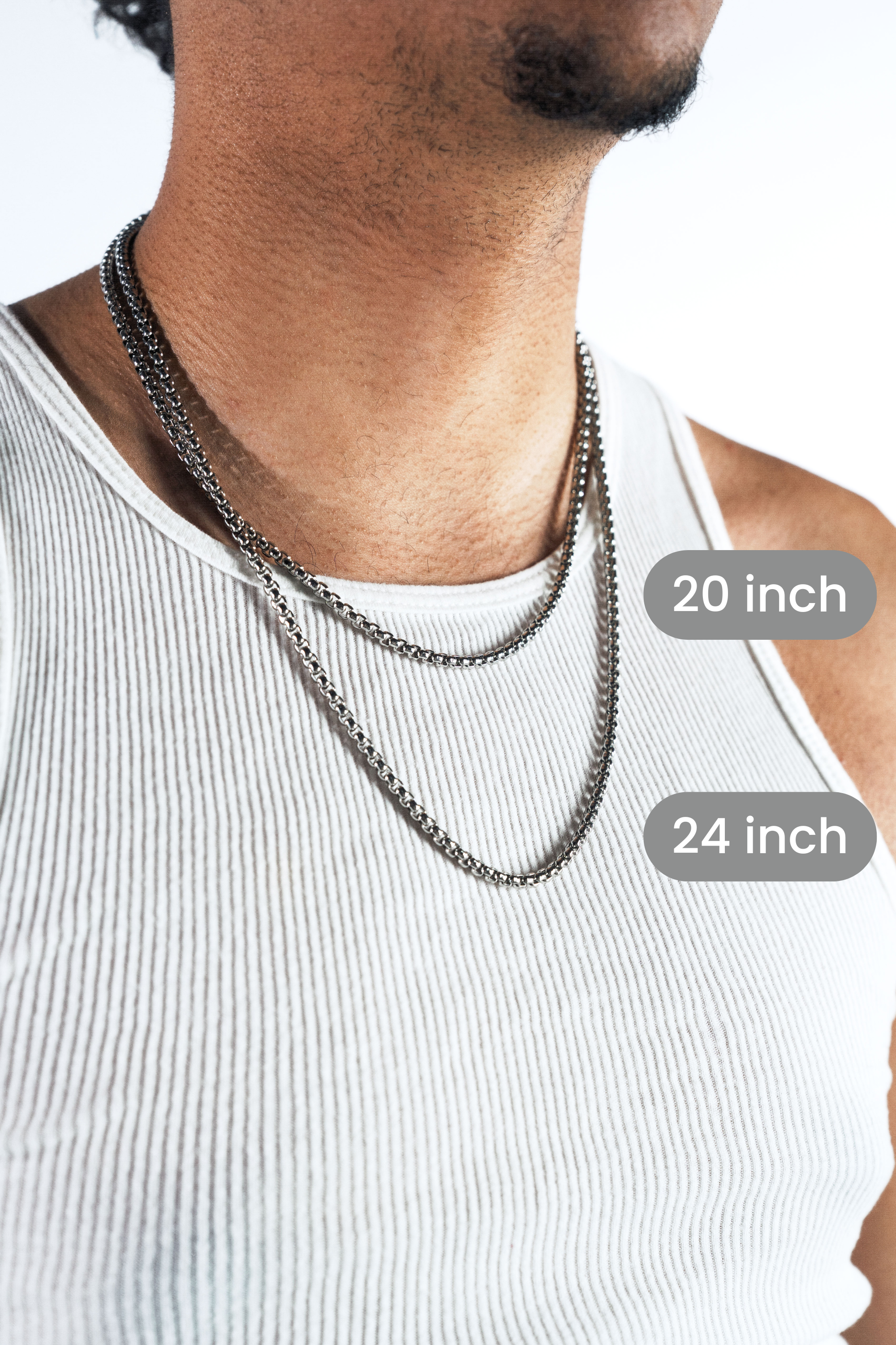 A close-up of a man wearing two silver-toned chain necklaces over a white ribbed tank top, with overlaid labels showing 20 inch and 24 inch lengths.