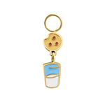 Gold enamel hoop charm resembling a chocolate chip cookie suspended over a cup of milk on a white background