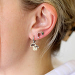 Close-up of a person's ear with multiple earrings.